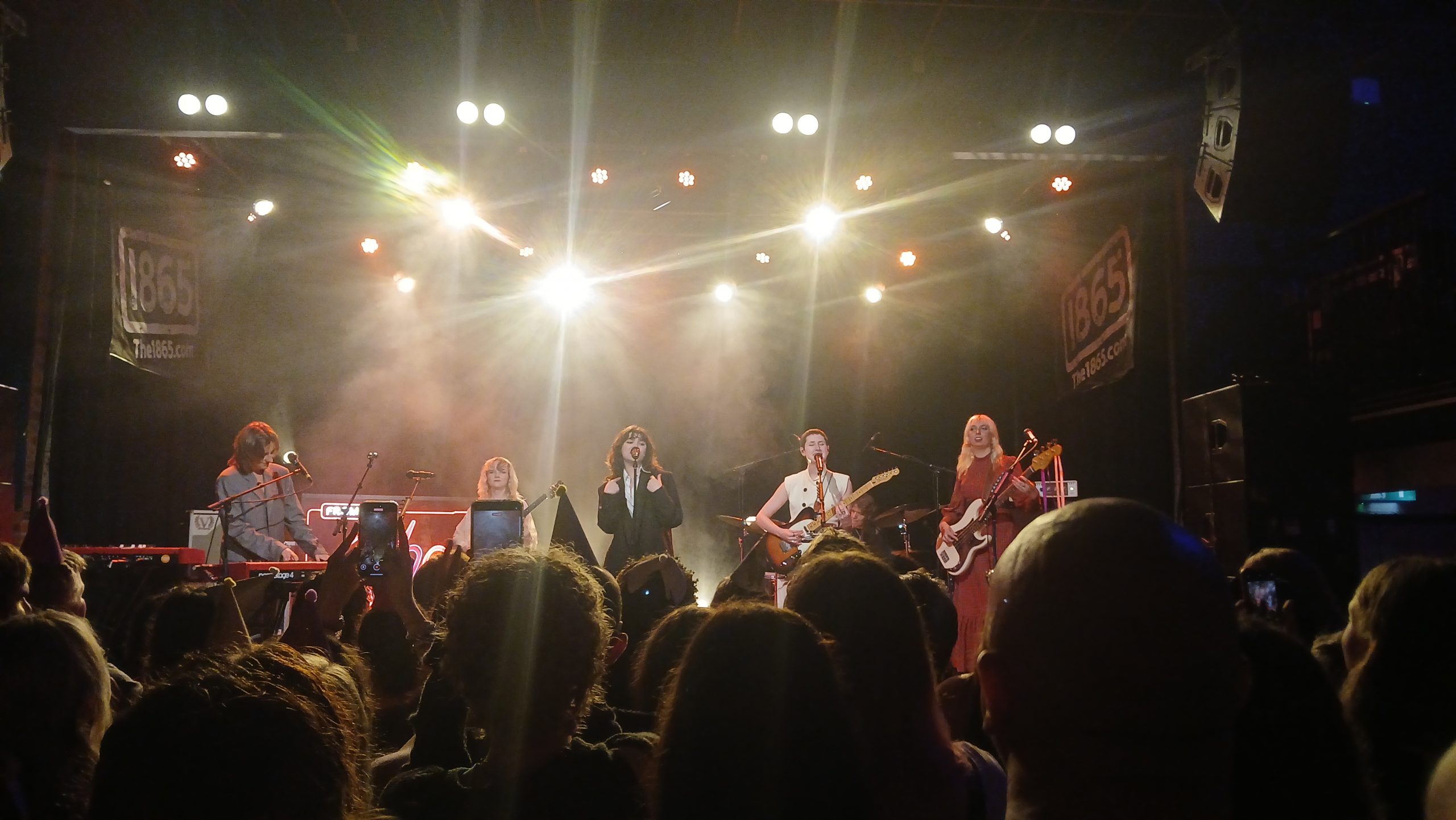 Photo taken by Meadbh Corbett. Aurora Nishevci, Emily Roberts, Abigail Morris, Lizzie Mayland and Georgia Davies on stage performing their song 'Agnus Dei'